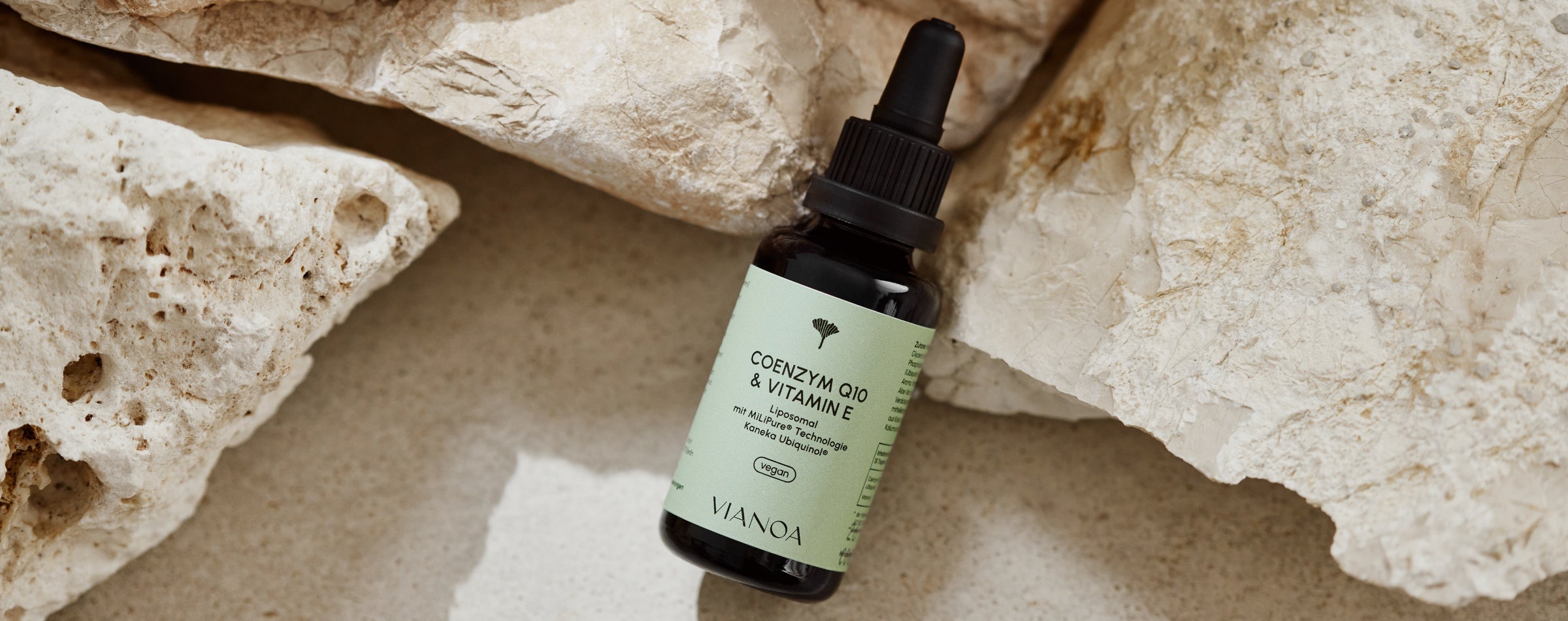 VIANOA Coenzym Q10 & Vitamin E Tropfen neben Stein