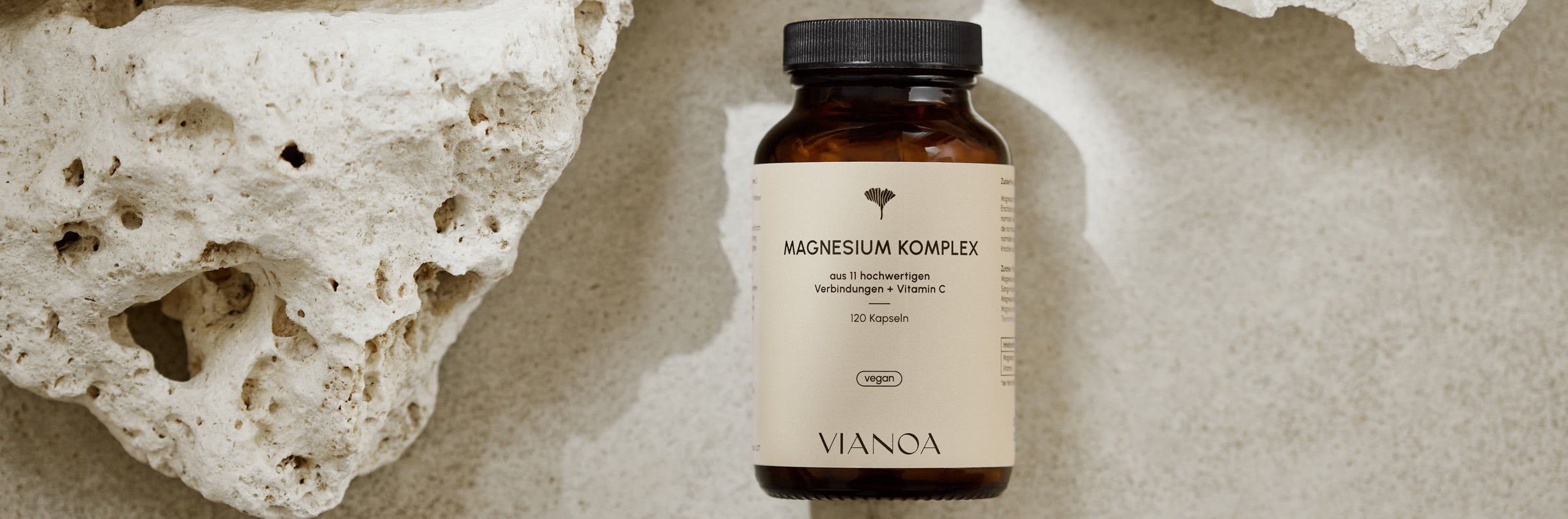 VIANOA Magnesium Komplex Kapseln neben Stein