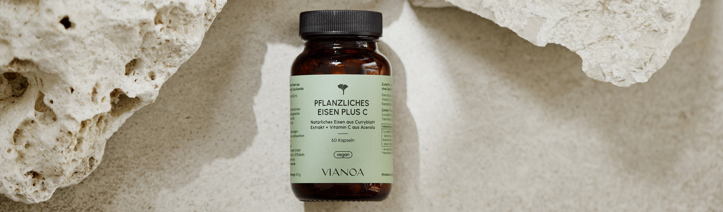VIANOA Pflanzliches Eisen plus Vitamin C Kapseln neben Stein